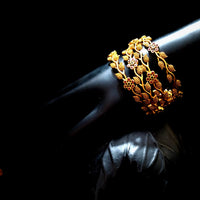 B036_Classy Gold plated bangles with flowery pattern embellished with pink and green ruby stones.