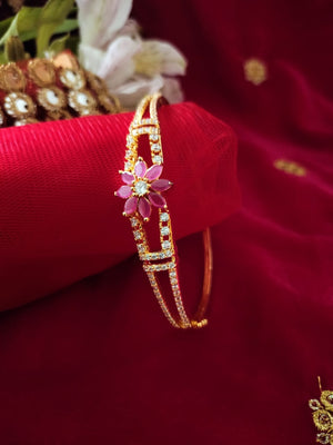 B0195_Lovely golden color bangle style flower design bracelet studded with dazzling american diamond stones with a touch of pink stones.