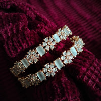 B0259__Elegant designer bangles with delicate designs studded with american diamond stones with a touch of ash color stones.