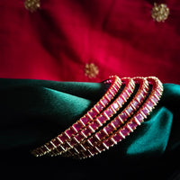 B0257_Gorgeous golden bangles embellished with a touch of pink ruby stones.