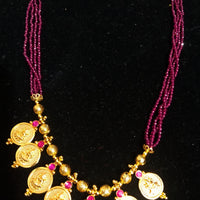 Pleasing and graceful gold plate-ted necklace laden with exquisite work of berry/wine purple colored crystals