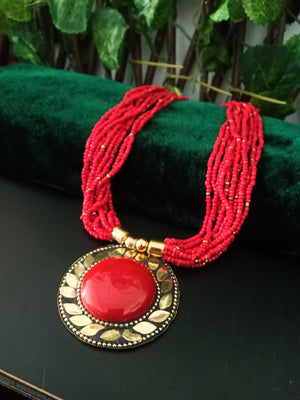 N0243_ Classic Off beat necklace with over sized circular pendant with a crimson red color stone with beautiful craft work followed by layered bead chains.