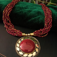 N0248_ Classic Off beat necklace with over sized circular pendant with a maroon color stone with beautiful craft work followed by layered bead chains.