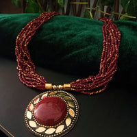N0248_ Classic Off beat necklace with over sized circular pendant with a maroon color stone with beautiful craft work followed by layered bead chains.