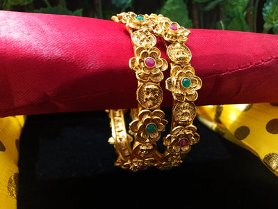 B041_Classic Gold plated flowery pattern bangles studded with pink and green ruby stones.