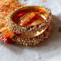 B0222_Lovely golden pearl bangles with delicate craftwork embellished with a bunch of pearls.
