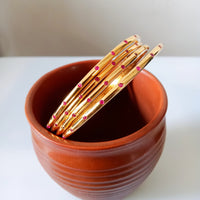 B0226_Beautiful sleek design  golden bangles with a touch of pink stones.