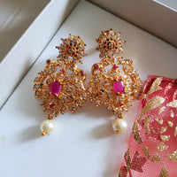 E0642_Gorgeous crafted earrings with delicate work of peacock design studded with american diamond stones with a touch of pink stones.