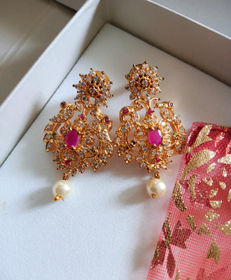 E0642_Gorgeous crafted earrings with delicate work of peacock design studded with american diamond stones with a touch of pink stones.