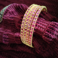 B0257_Gorgeous golden bangles embellished with a touch of pink ruby stones.