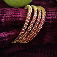 B0257_Gorgeous golden bangles embellished with a touch of pink ruby stones.