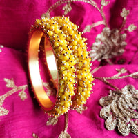 B0273_Lovely golden pearl bangles with delicate craftwork embellished with a bunch of yellow beads.