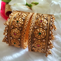 B0281_Grand broad style Ethnic screw design bangles with delicate work with a touch of ruby and american diamond stones along with bead drops.