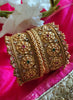 B0281_Grand broad style Ethnic screw design bangles with delicate work with a touch of ruby and american diamond stones along with bead drops.
