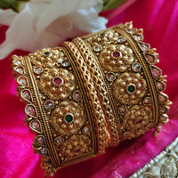 B0281_Grand broad style Ethnic screw design bangles with delicate work with a touch of ruby and american diamond stones along with bead drops.