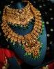 N03068_ Grand classic matte gold polished temple jewelry choker style and Long Haram crafted design gold plated necklace set embellished with ruby and green stones .